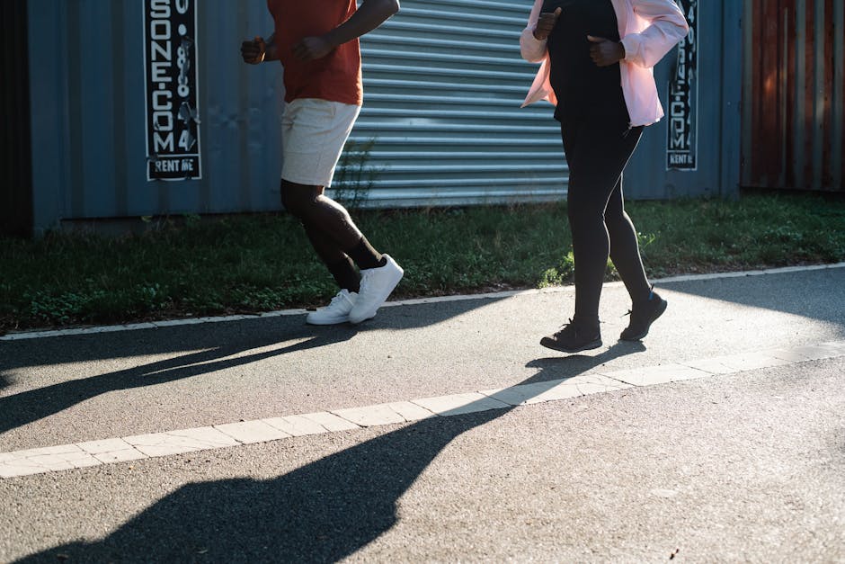 Two people jogging outdoors on a sunny day, emphasizing fitness and healthy lifestyle.