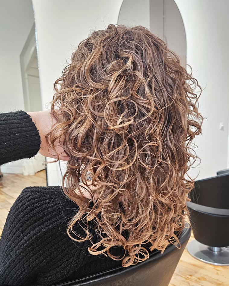 Krullend haar verzorgen in de zomer: dit heb je nodig!