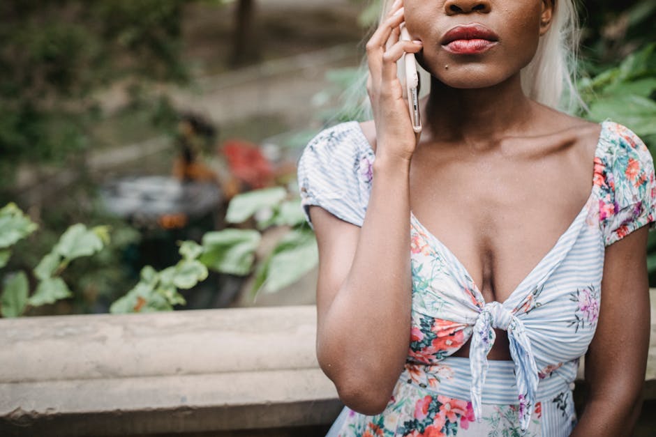 Close-up of a woman in floral dress speaking on her smartphone while outdoors, capturing modern lifestyle.